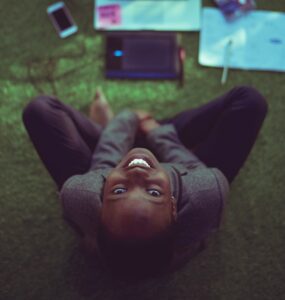 top view photo of woman sitting near MacBook Pro facing the camera