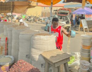 A man standing under an umbrella in a market