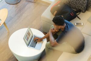 man sitting on couch using MacBook